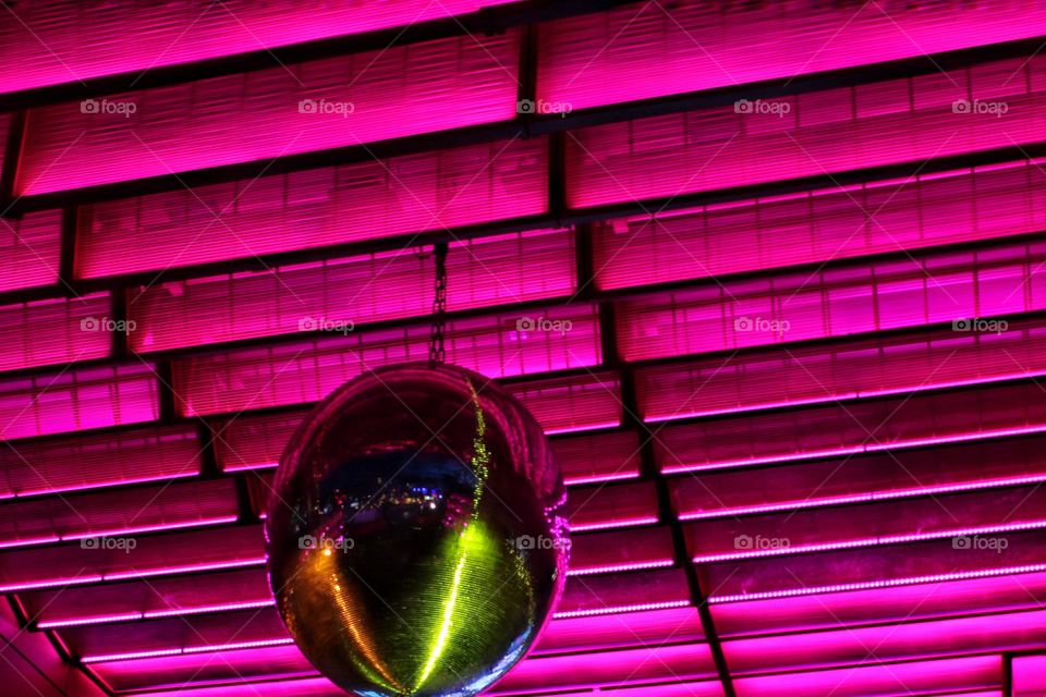 Pink illuminated ceiling with disco ball at night 