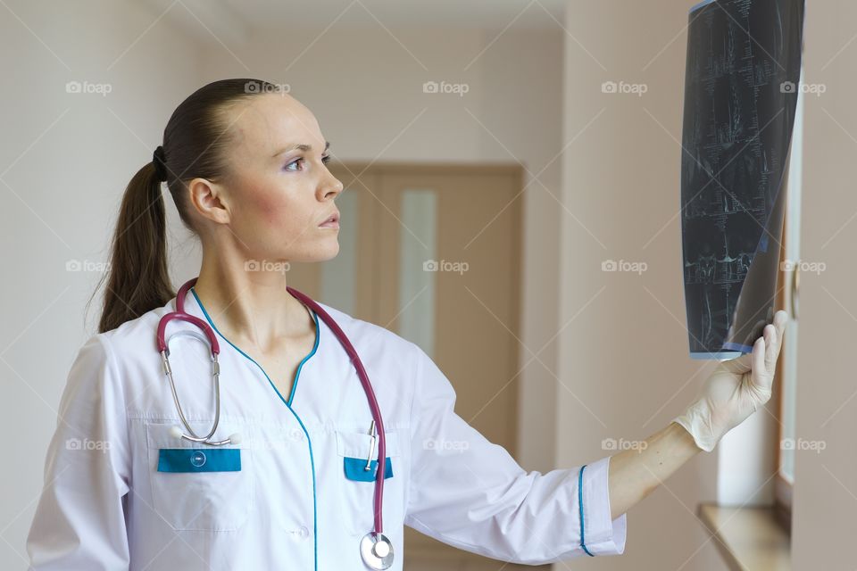 Young doctor checks x-rays film.