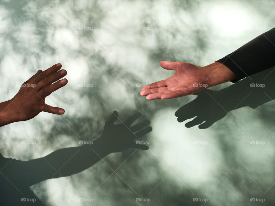 Two hands and shadow on the wall