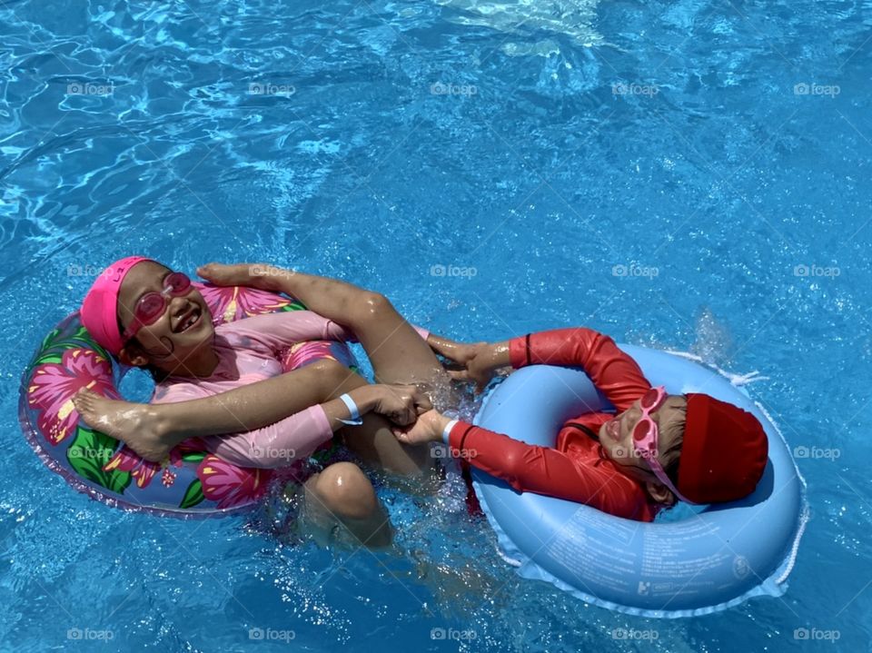 Sisters playing in swimming pool 