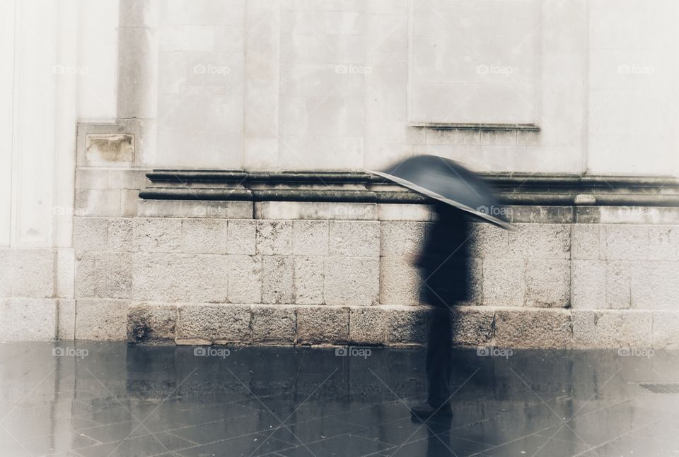 Blurry person with umbrella in the rain