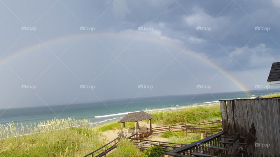 Serene,  scenic,  magnificent double rainbow after brief rain Shower at the beach oceanfront seashore grass summer rental vacation at the Outer Banks North Carolina