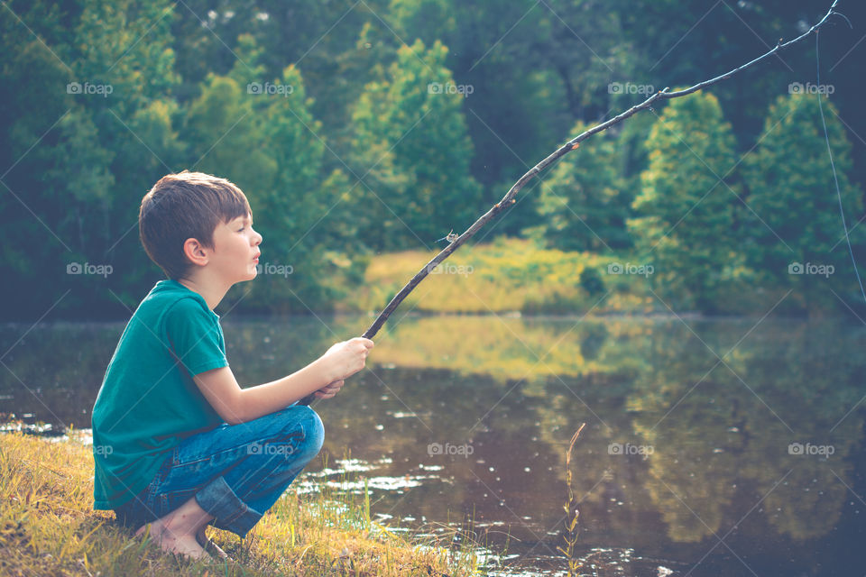 Young Boy Fishing in a Pond with Homemade Pole 2