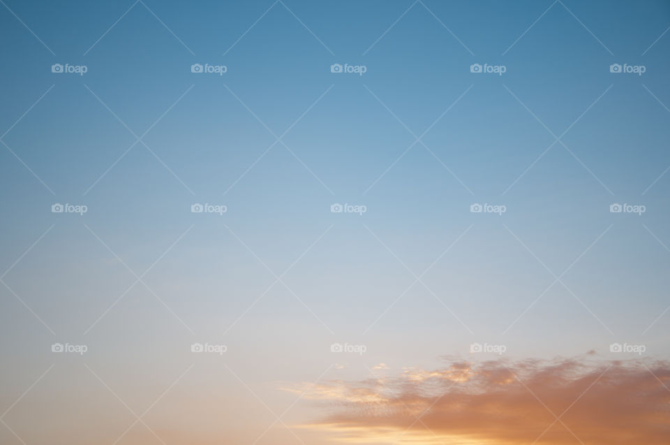 Small cloud in a blue sky at sunset