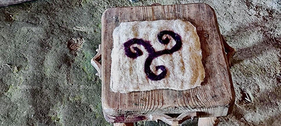 This ageless design adorns a handcrafted pillow on top of a handwoven wicker rattan chair in the “Keltendorf Gabreta”, a newly erected Celtic village near the township of “Ringelai” in “Bavaria”, Germany. 2023. Hypnotic Productions