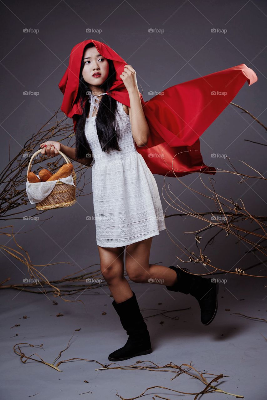 The little red riding hood holding a basket of bread 