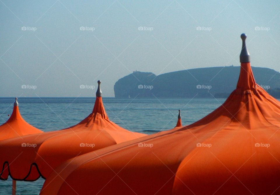 orange color story: orange sea umbrellas in front of mediterranen sea