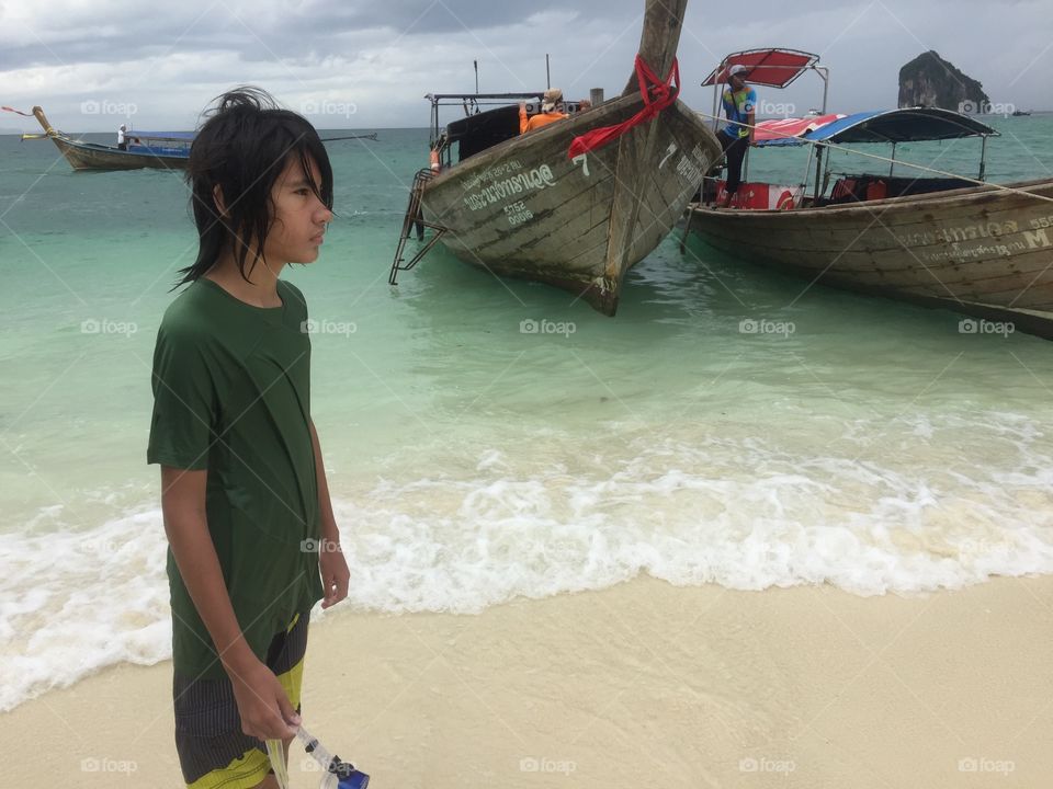 A little boy contemplating on the beautiful scenery in Krabi, southern part of Thailand. 