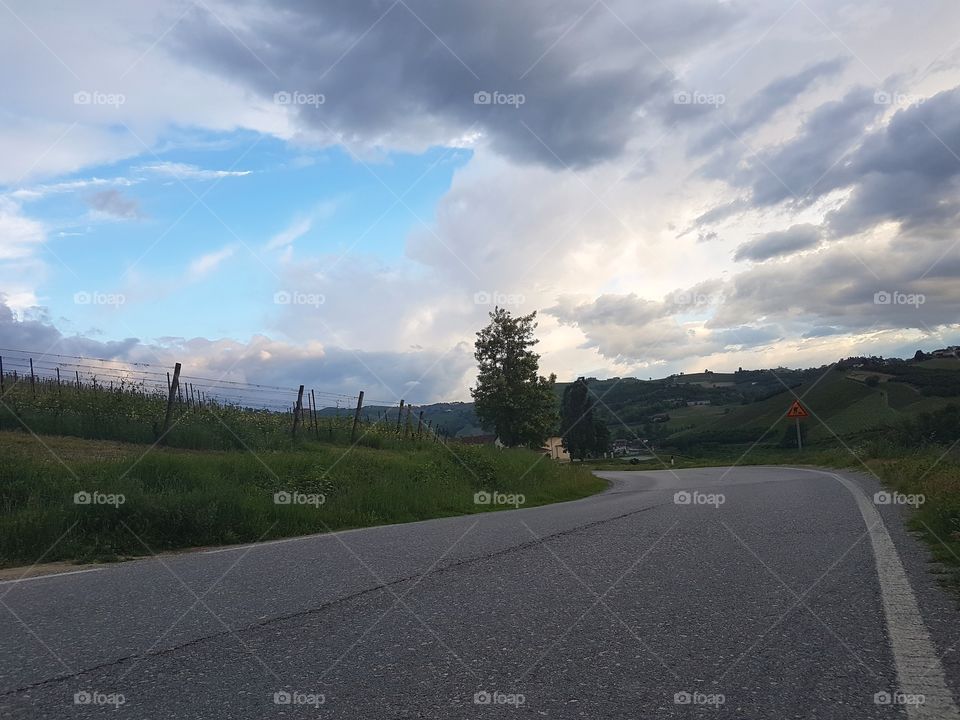 Country road with cloudy sky in Italy