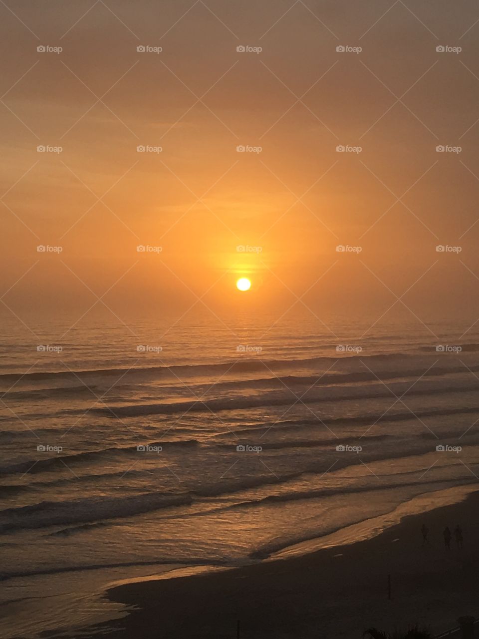Perfectly round sun setting over the ocean