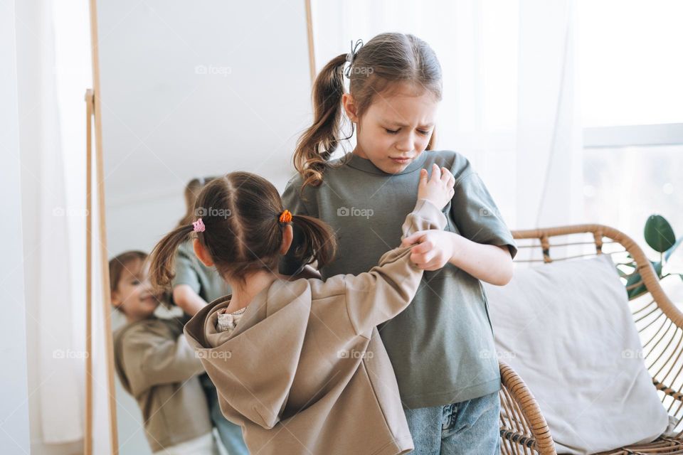 Little girls sisters have fight near mirror in children room at the home