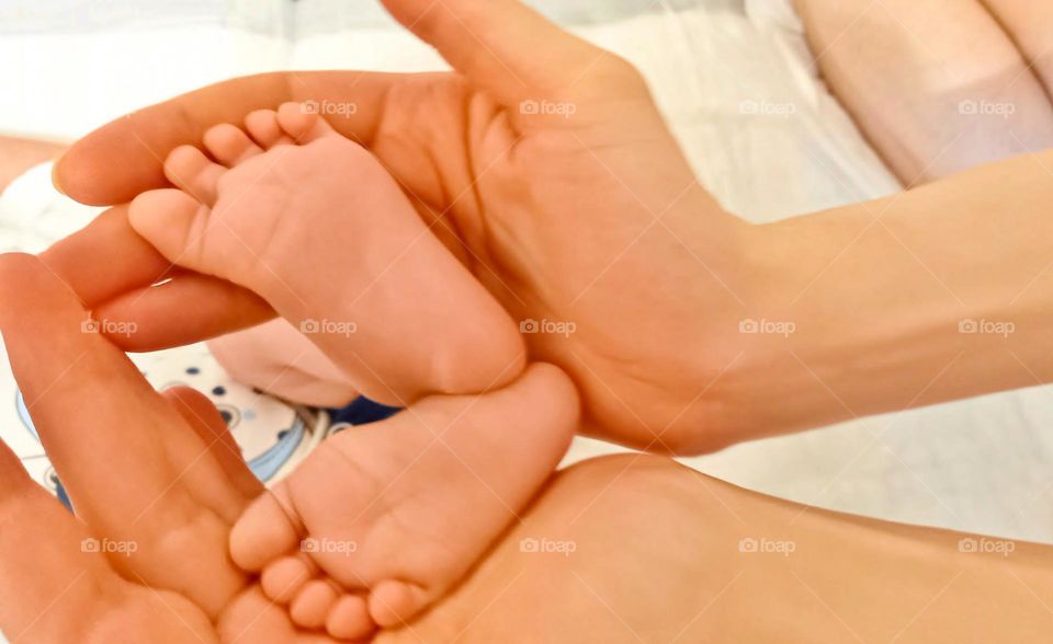 Baby's legs in mother's hands