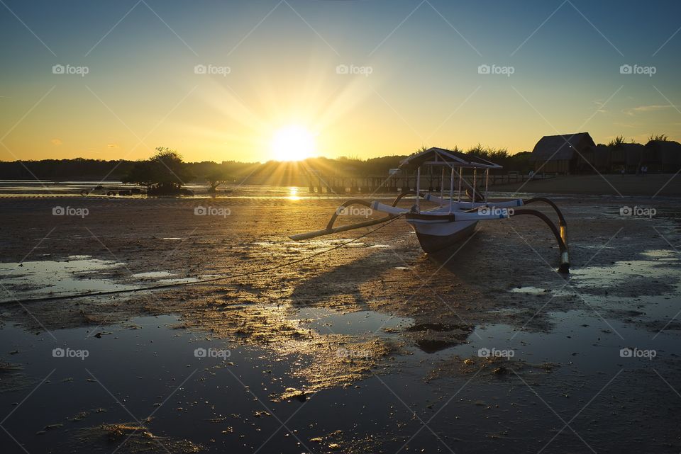 sunset view and small boat known as jukung