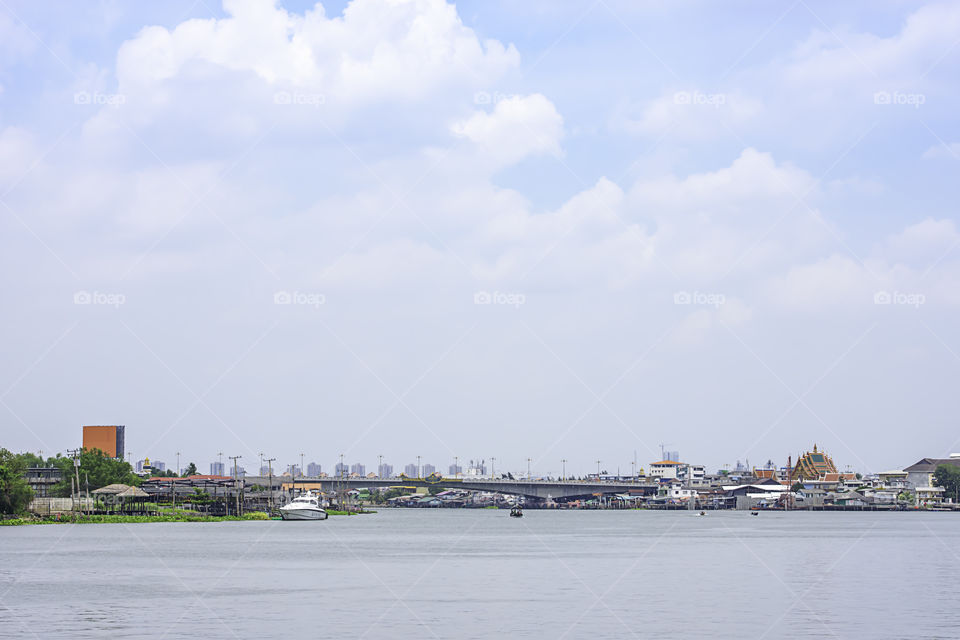 Ships crossing in Chao Phraya River and cityscape Background sky and clouds at Pak Kret in Nonthaburi , Thailand. April 16, 2019