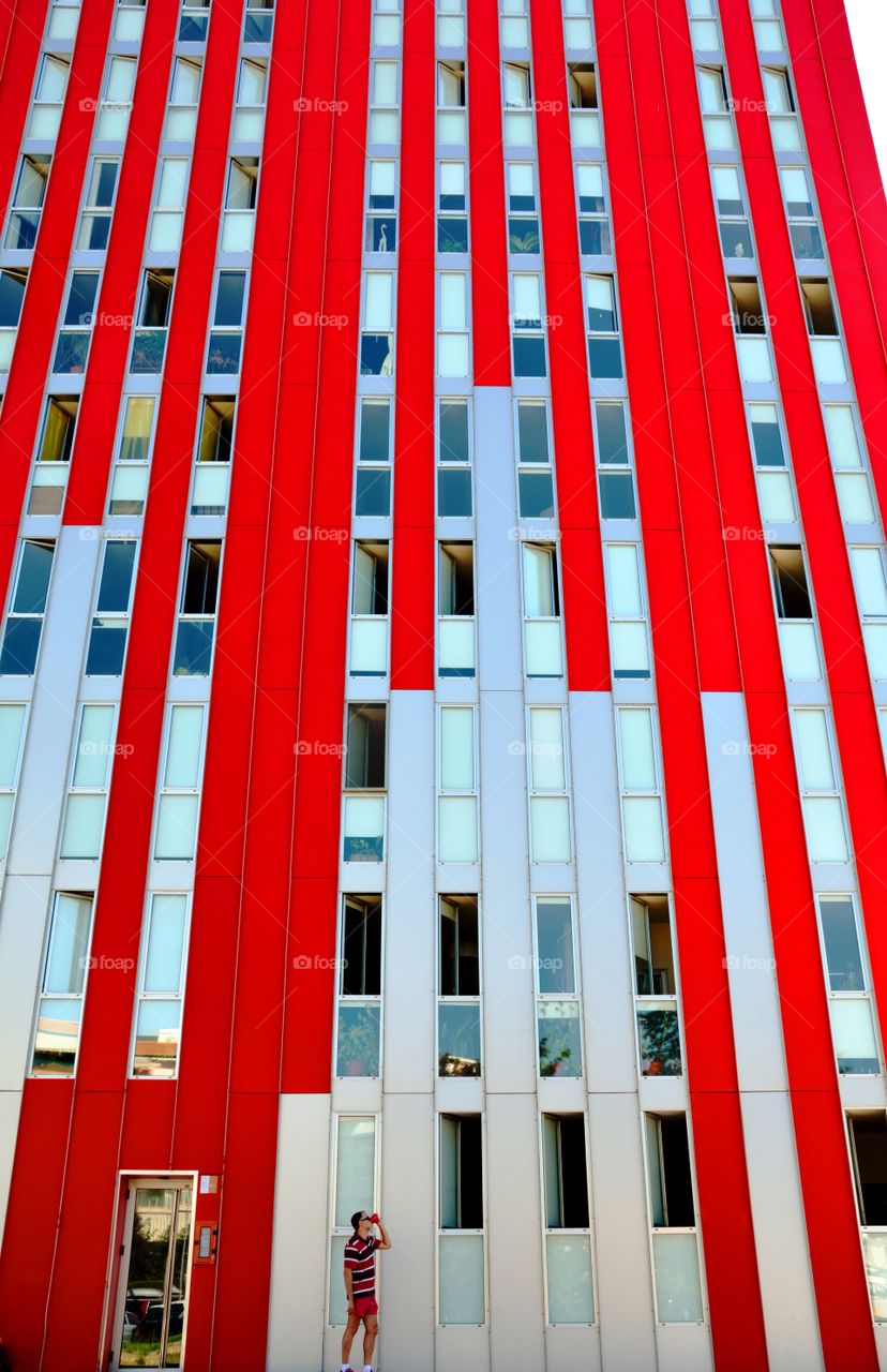 one person alone drinking and a red high building
