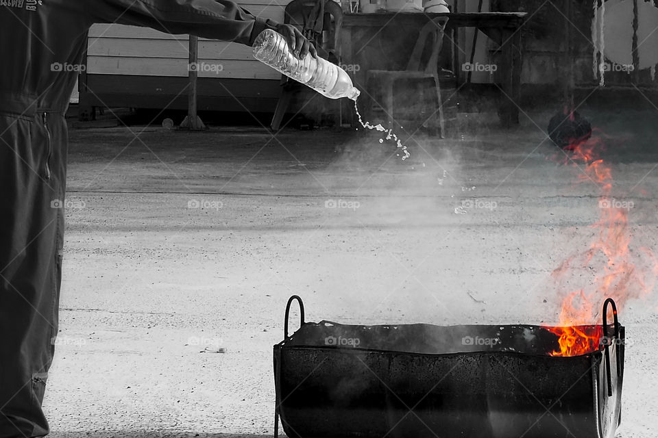 Man pouring bottled water on a fire