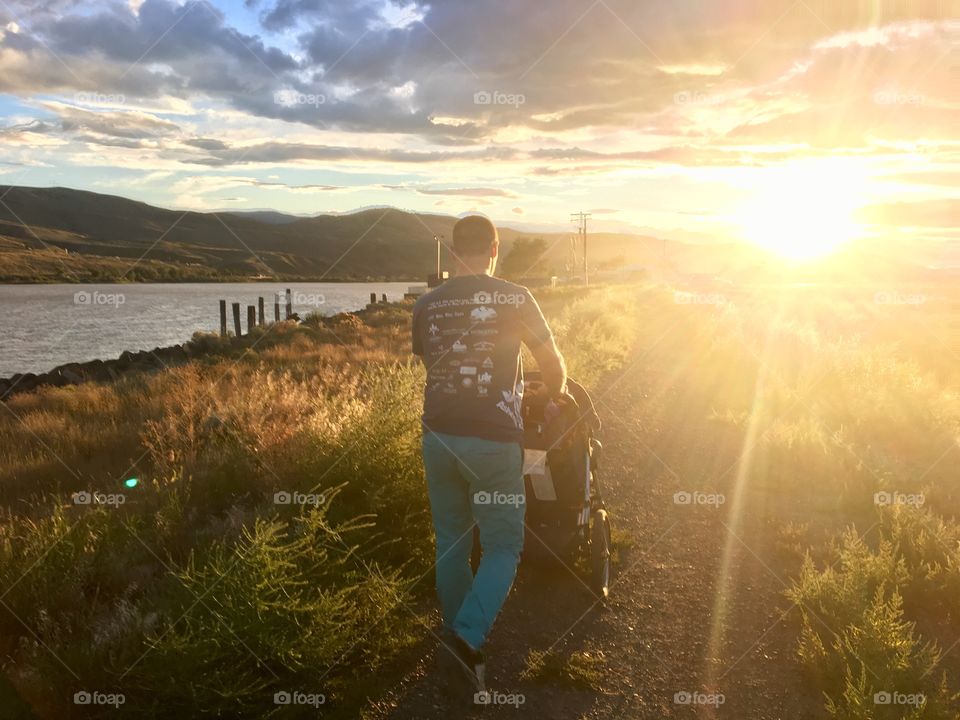 Dad walking baby at sunset 