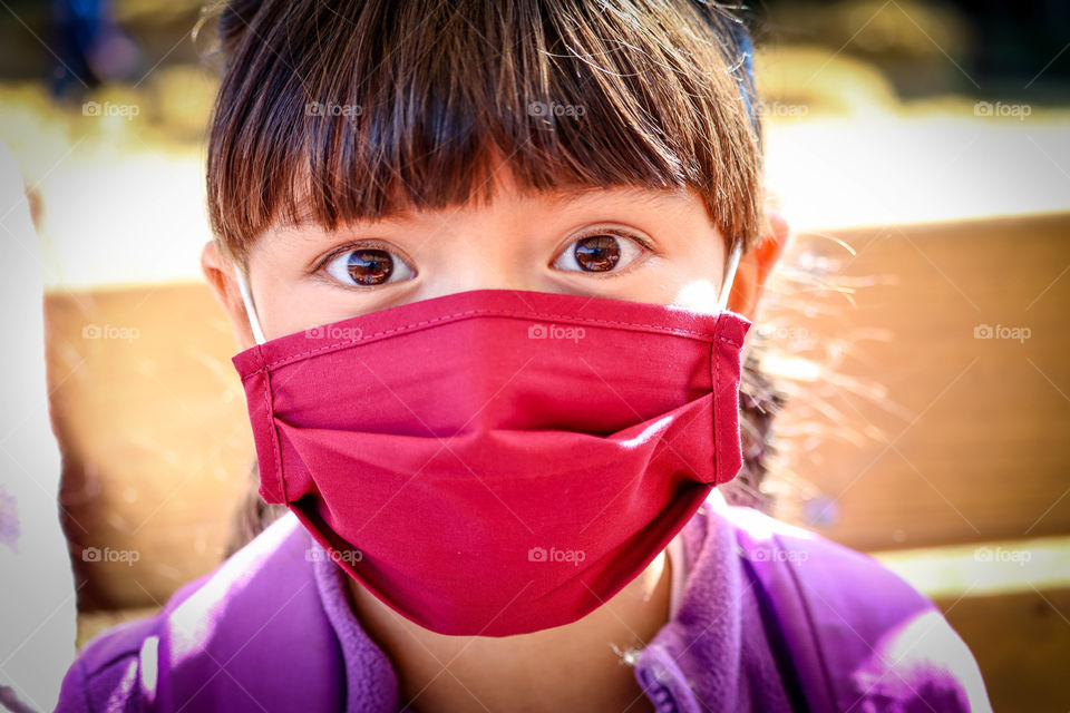 Cute little girl in a red face mask