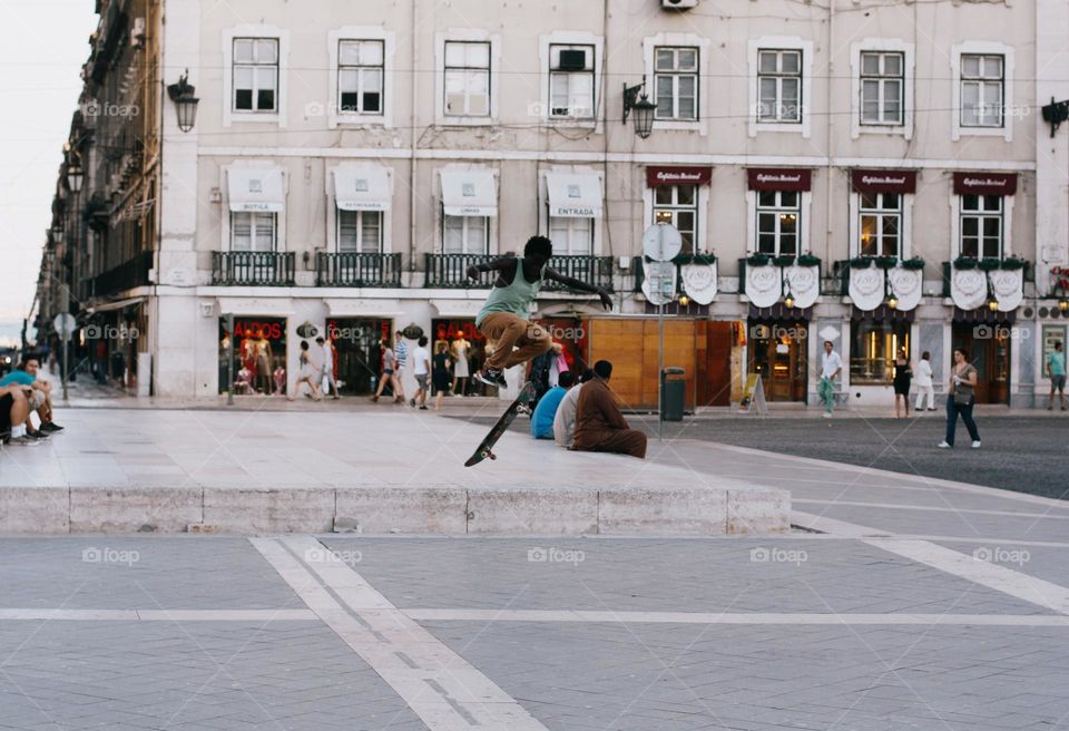 A young black guy skateboarding on a warm summer day