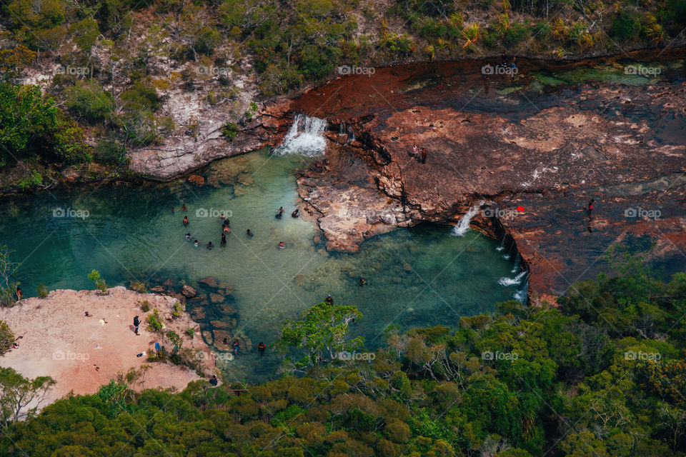 Aerial view. Australian Aboriginal people are swimming in the river near waterfall