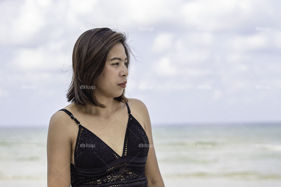 Portrait of Asian woman wearing a swimsuit background sea and sky