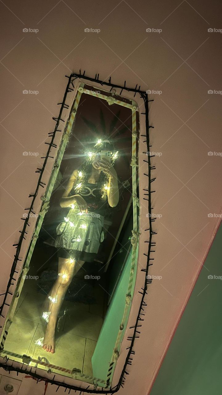 Curly-haired girl in a dark room with strands of light