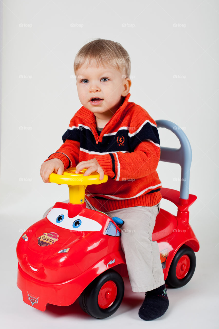 Toddler on plastic sitting against white background 