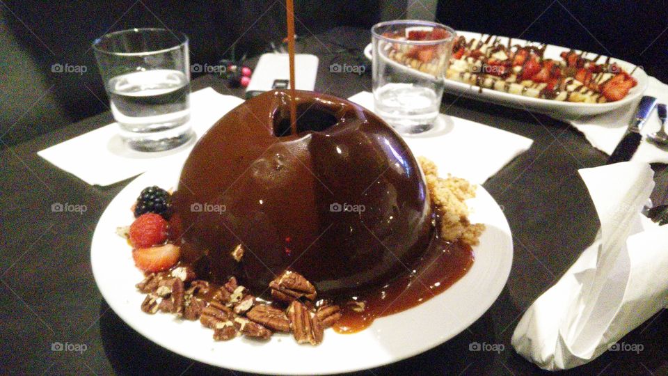 chocolate dome bowl starting to melt with hot caramel cracking top of the dome