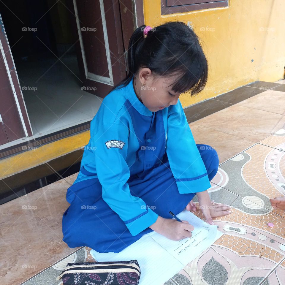 Little girl studying in the yard
