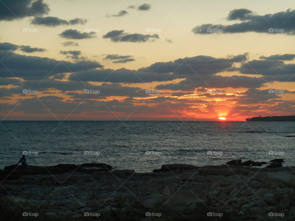 man on a sunset sea shore summer time