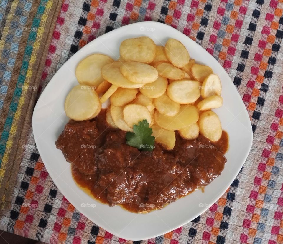 beef with tomato sauce and round french fries plate, dish, meal