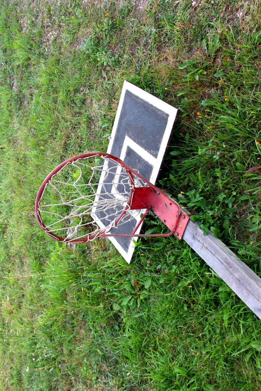 is the basketball hoop against the grass wall or is it on the grass?