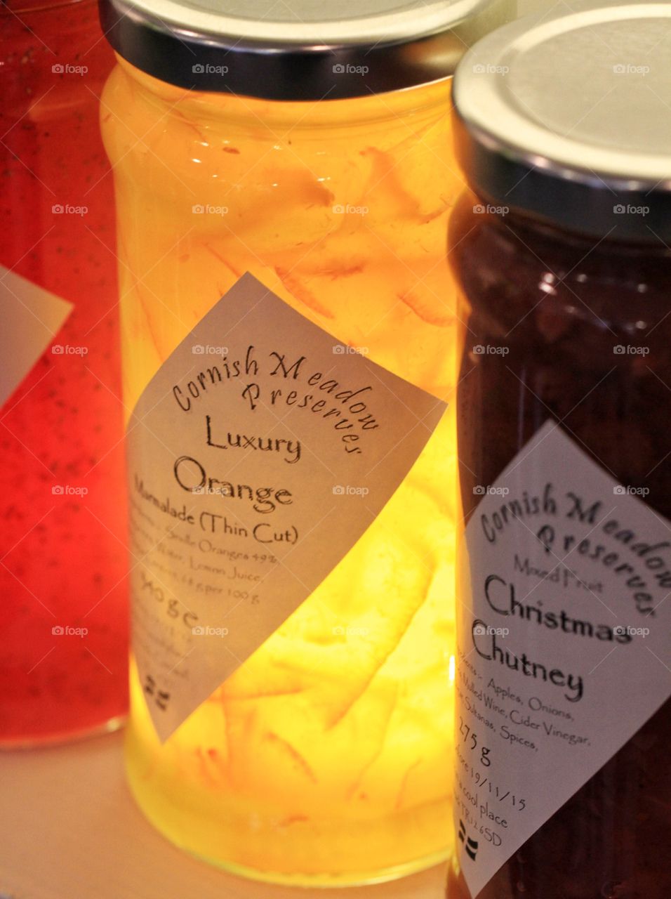 A row of home made preserves including jams and marmalade.