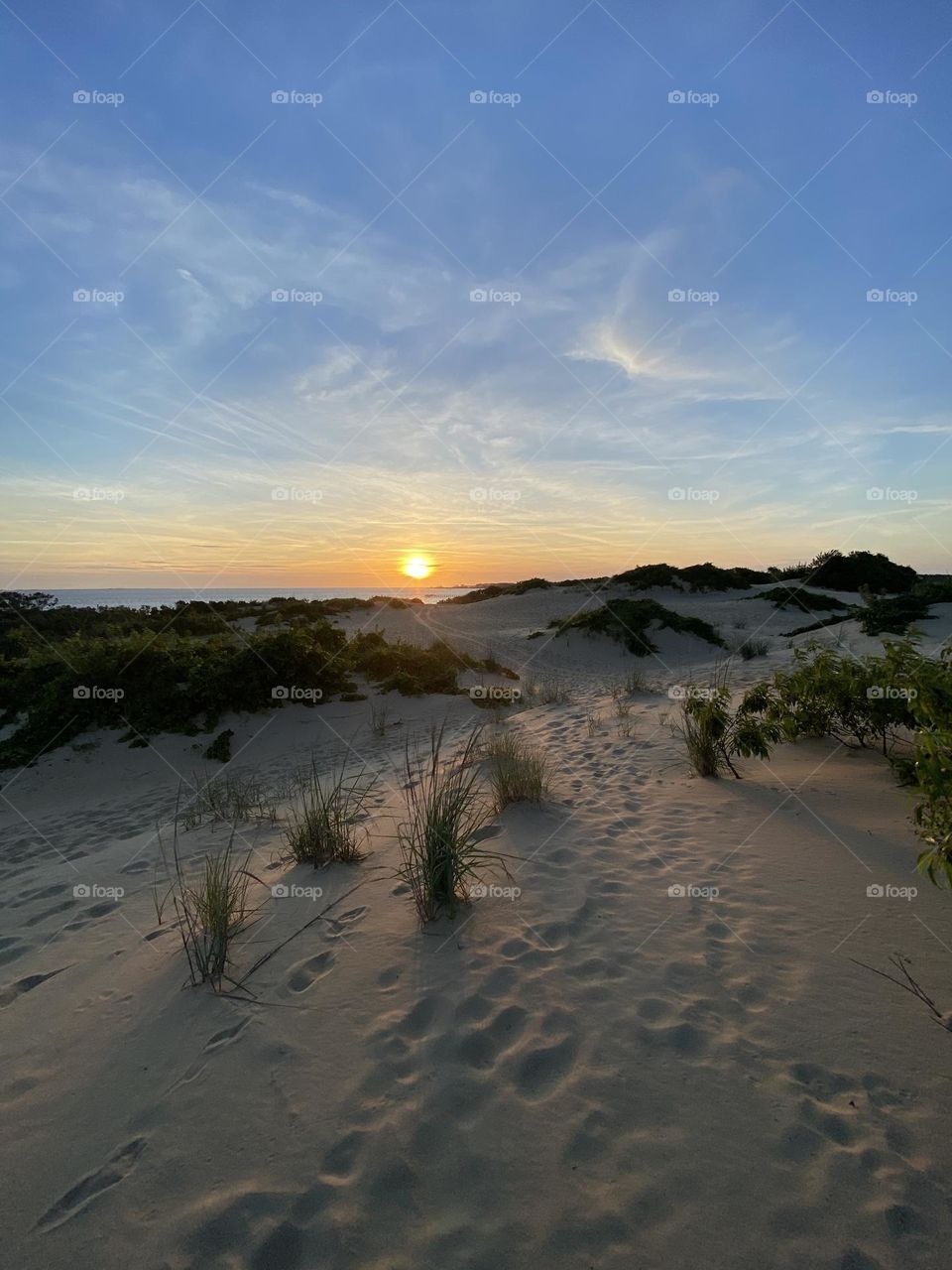 Sunset over the dunes and bay .