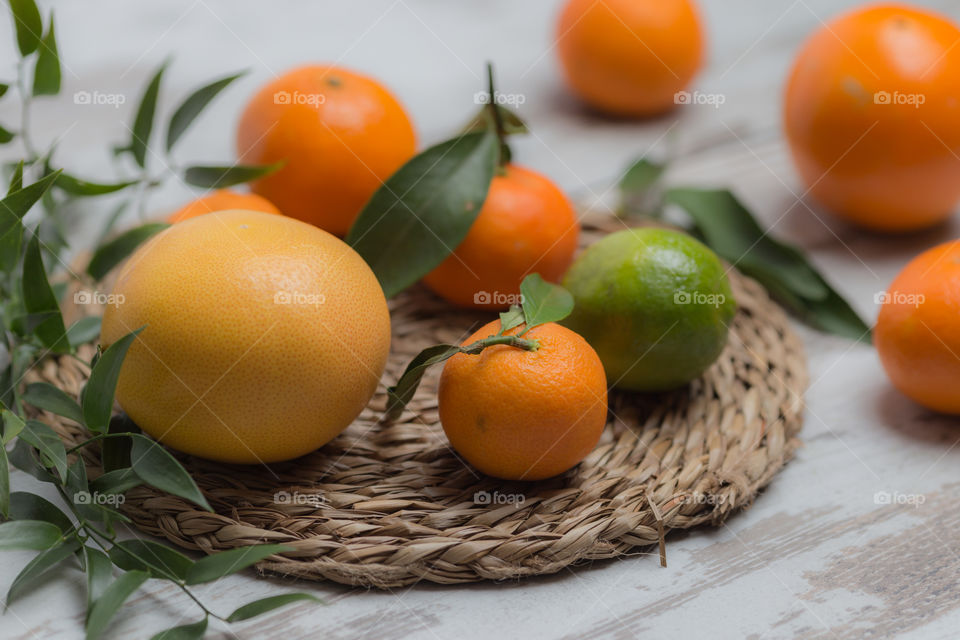 Orange and lime friuts on mat