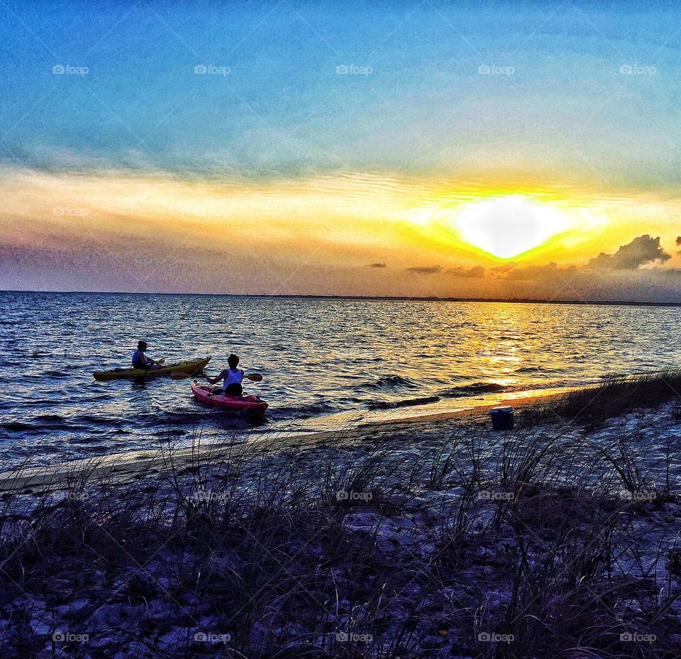 A couple kayaking in the sunset