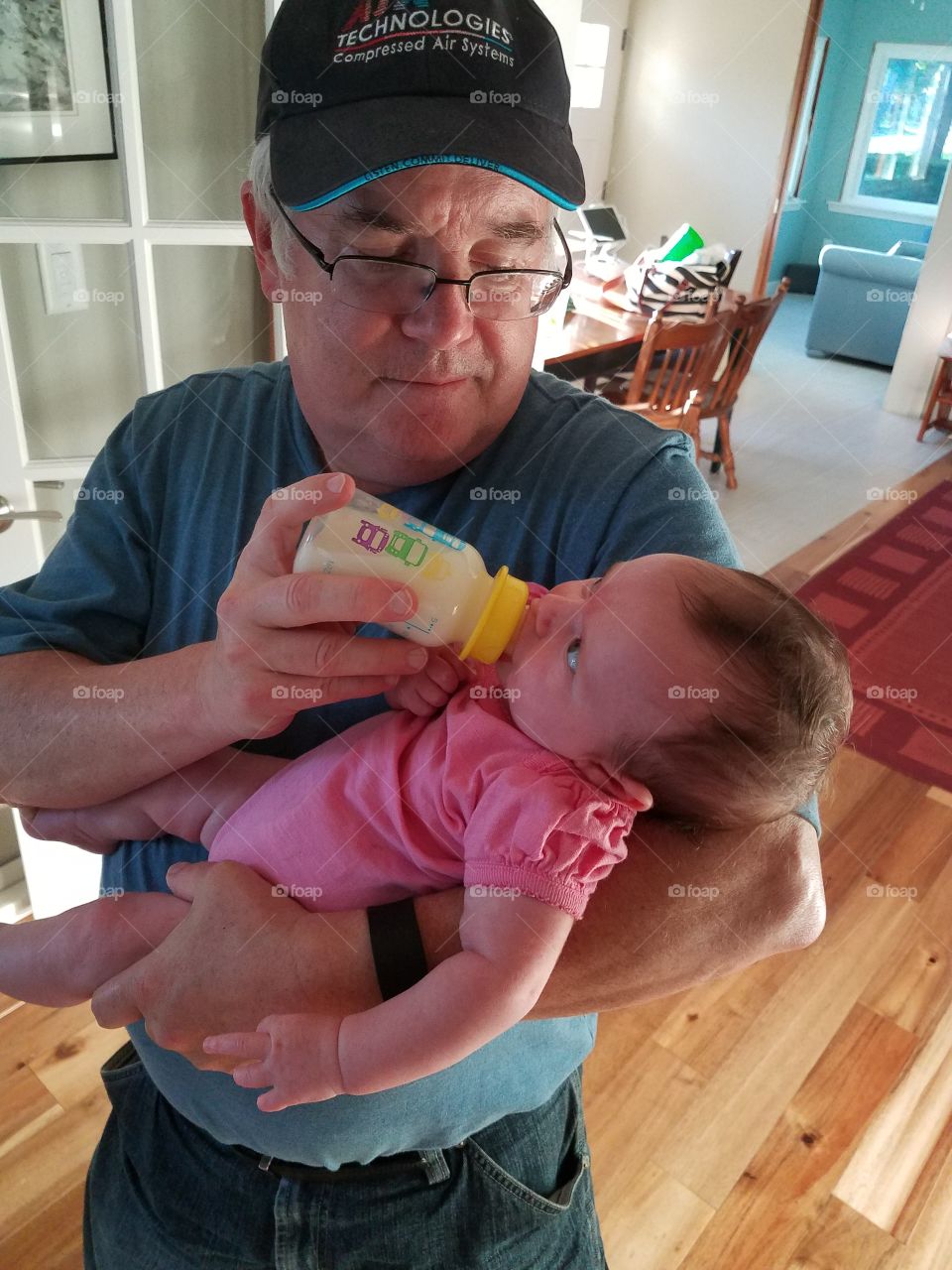 Grandfather feeding milk to her grand daughter