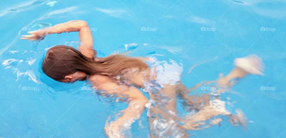 Girl swimming in pool with head under water