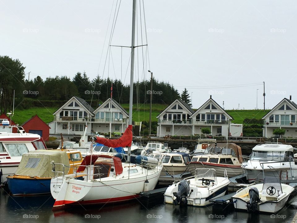A sailboat and small boats moored  in the  guest harbour at the island Herdla, Herdlafjord, Norway