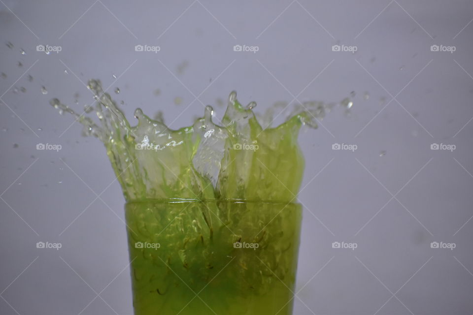 green color juice splash in glass