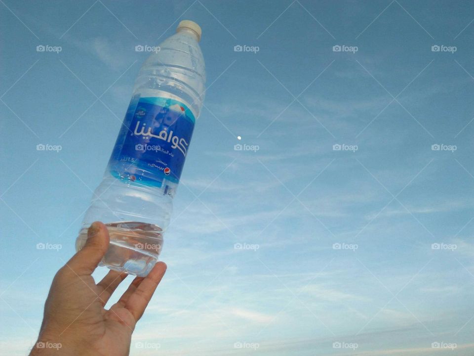 Beautiful bottle embraced blue and white sky.