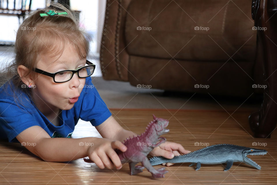 Little girl playing with her favorite dinosaurs