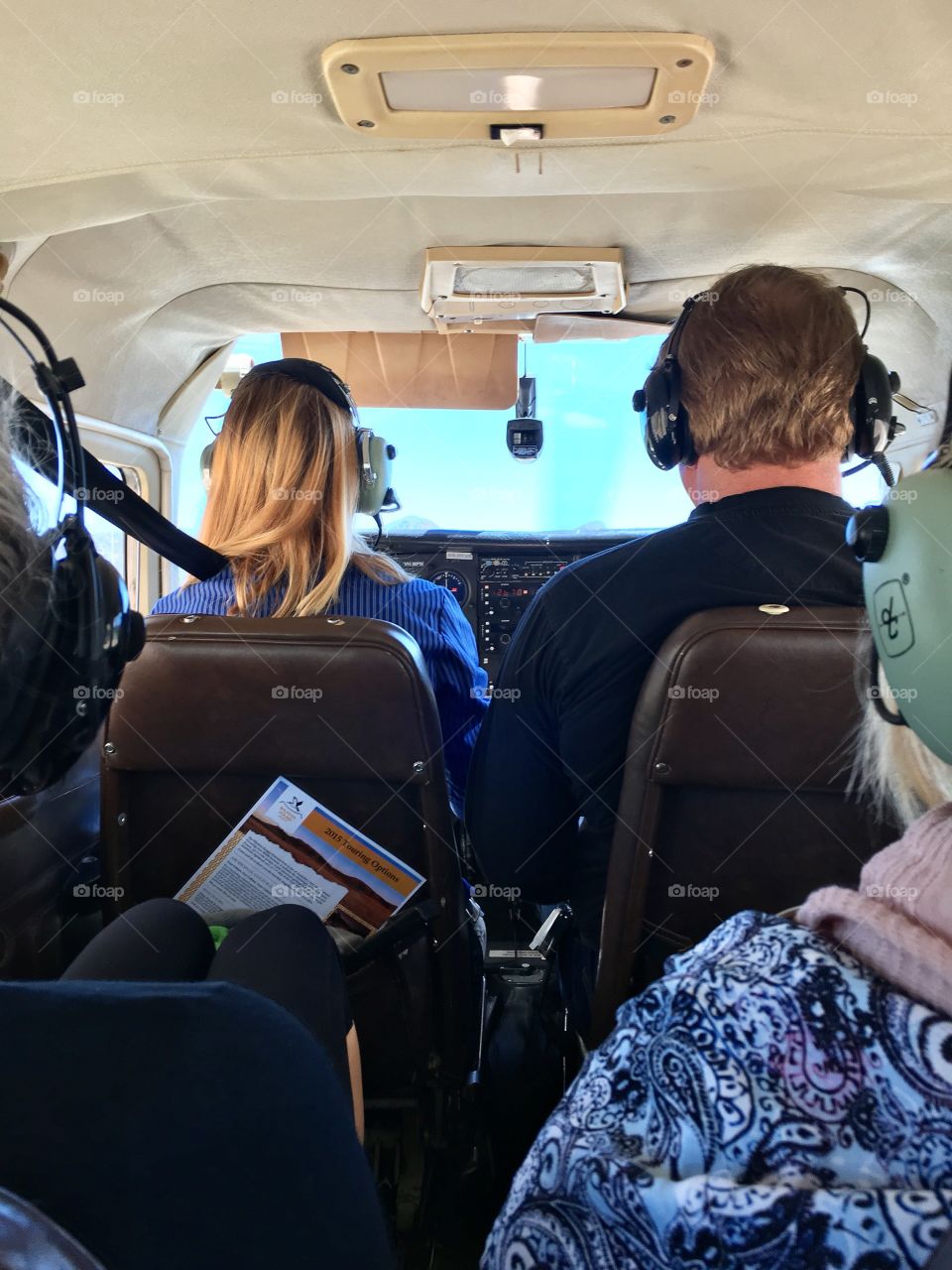 Group of passengers inside small aircraft plane with female pilot 