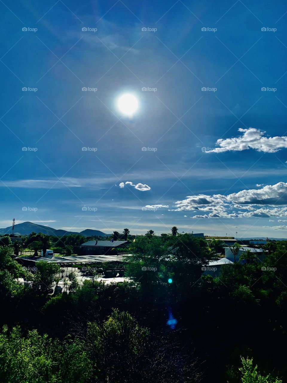 Sun is  about to set and it’s hotter than ever. A view from my bedroom over a green valley.