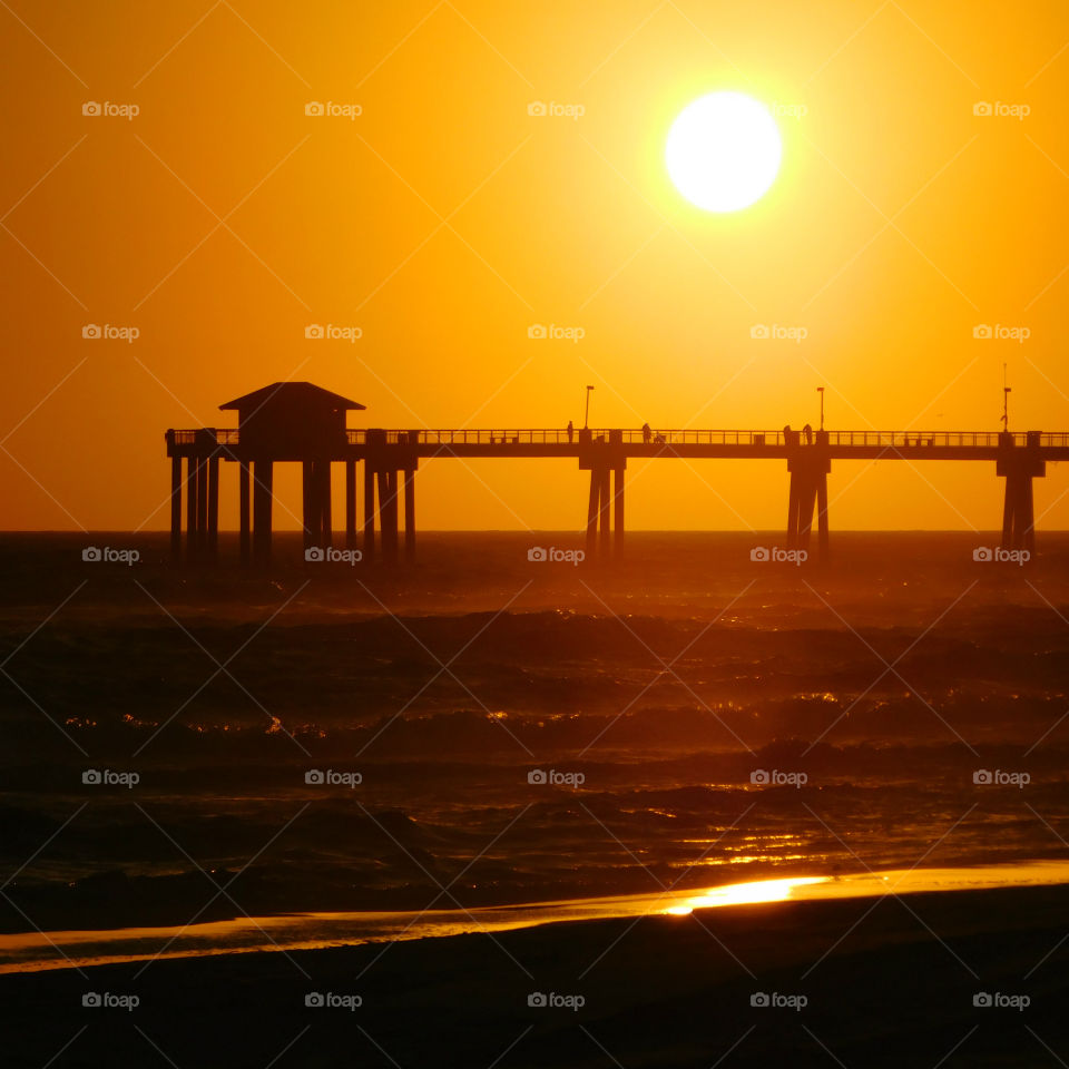 Silhouette of pier over sea at sunset