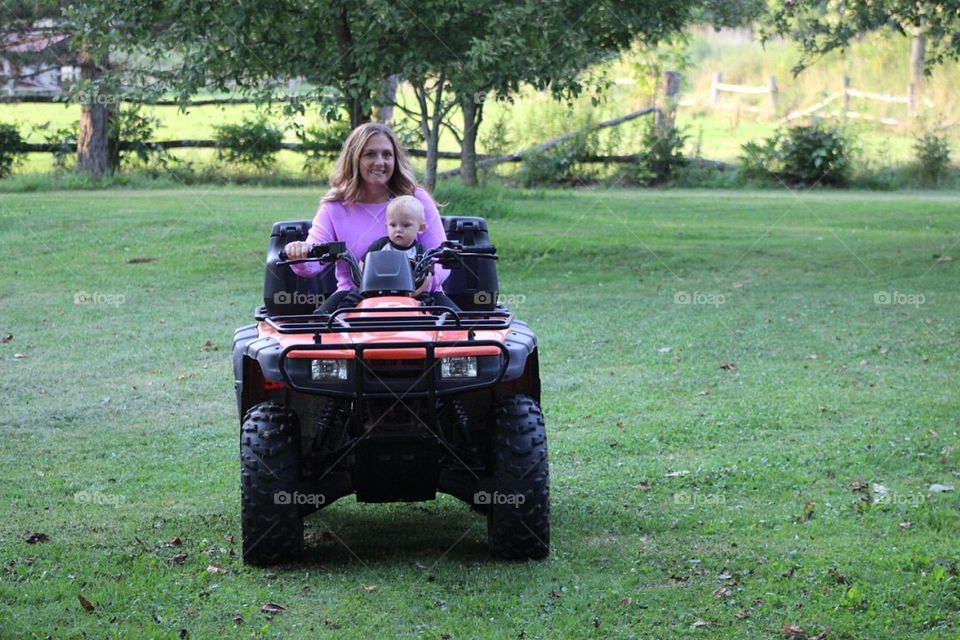 Mommy and baby taking a short four wheeler ride. 