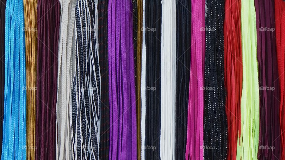 Many hanging.  shoelaces of different colors for sale outside a storefront in San Miguel de Allende, Mexico
