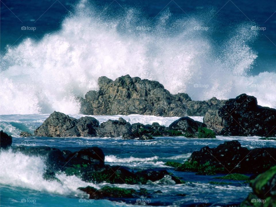 Waves break against rocks ocean