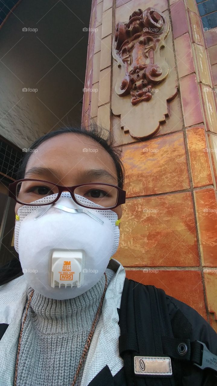 Woman with mask on for smoke protection due to Oakland fires