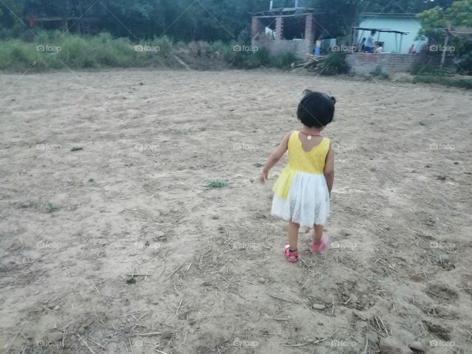 Baby girl playing in open field and enjoying their childhood